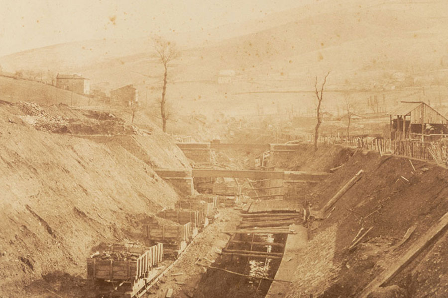 Old sepia photo of railroad cars in industrial landscape, "Railway Scene, Factory at Terre-Noire" by Gustave Le Gray, France, 1850s