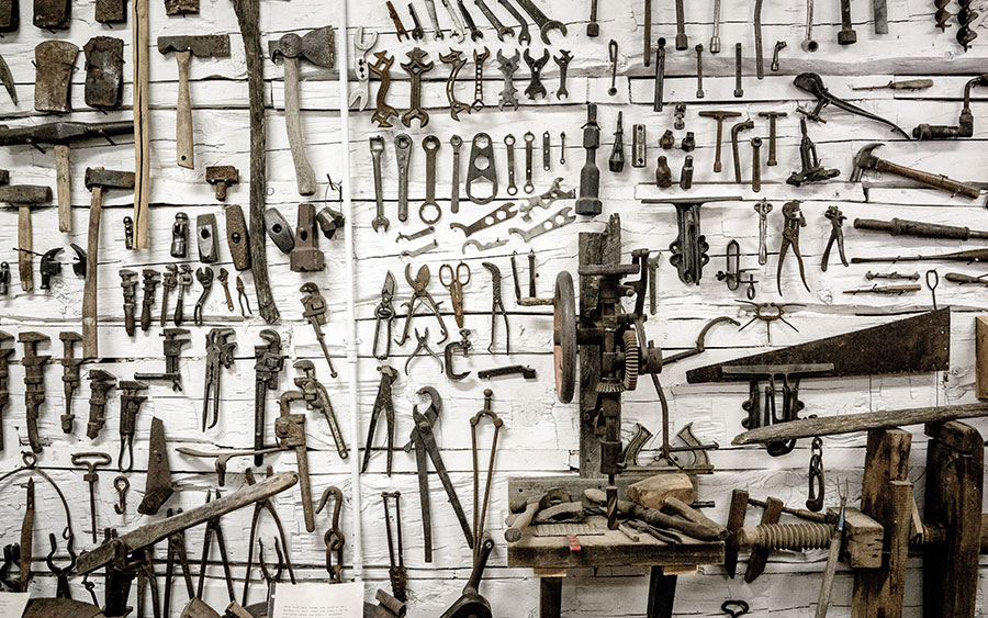 Photo of a wall with old tools on a white wooden wall
