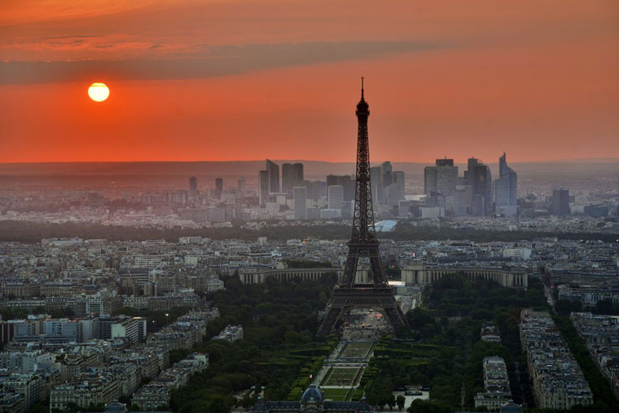 Photo of Paris with a orange hazy sunset with the Eiffel tower in the forefront
