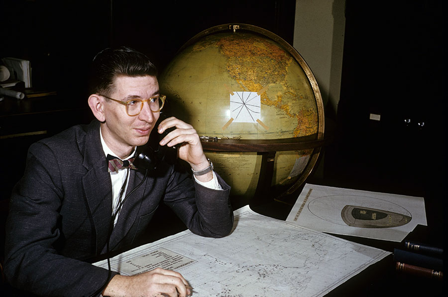 A photo of a man in office talking over the phone in the 1950's